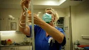 Eine Krankenschwester bereitet eine Infusion f&uuml;r einen Patienten vor.