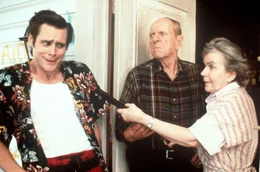Die Eltern von Ray Finkle, Mr. Finkle (Bill Zuckert, Mitte) und Mrs. Finkle (Alice Drummond, r.), sind weniger begeistert, als Ace Ventura (Jim Carrey, l.) pl&ouml;tzlich vor ihrer Haust&uuml;r steht und in der Vergangenheit ihres Sohnes herumschn&uuml;ffelt.