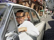 Der Marburger Friseur Ferdinand Kilian (Robert Kratz), eine stadtbekannte Figur, in seinem "ber&uuml;hmten" Ford 17M auf der Fahrt durch die Marburger Oberstadt.