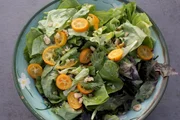 Frischer Blattsalat mit Kumquats und einem Kumquat-Dressing.