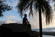 Brett Tutor sits atop the stone marker at sunset.