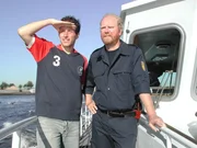Willi Weitzel mit einem Zollbeamten auf dem Zollschiff im Hamburger Hafen. Mit ihnen ist Willi unterwegs, um einen Bananenfrachter aus Kolumbien auf Schmuggelware zu durchsuchen.
