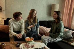 Jann (Philip Günsch) sitzt mit seiner Mutter Lina (Marie Leuenberger, r) und Selma (Mina-Giselle Rüffer, M) mehr oder weniger schweigend auf dem Sofa.