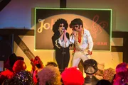 Kati (Diana Amft) als Diana Ross und Killmer (Uwe Ochsenknecht) als Elvis Presley begeistern in voller Montur das Publikum in der Karaoke-Bar.