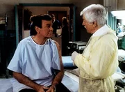 Dr. Mark Sloan (Dick Van Dyke, r.) gibt dem Detektiv Mannix (Mike Connors, l.) zu verstehen, dass er sich dringend einer Operation unterziehen m&uuml;sste ...