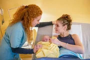 Hanna (Valerie Eisenbart, r.) hat ihre Tochter (Olivia Eleni Angelie, M.) unerwartet zur Welt gebracht. Ihre gro&szlig;e Schwester Meike (Sarah Hannemann) ist heilfroh, dass es beiden gut geht.