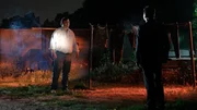 RECREATION - Homicide Lead Investigator Deckard (Peter Mastine) talks with Gerald Cruz (Paul Anthony Turner) at The Camp, by camouflage clothes hanging on clotheslines.