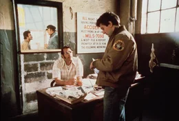 Nach dem Krieg findet Travis Bickle (Robert De Niro, r.) einen neuen Arbeitgeber (Joe Spinell, l.) und bekommt einen Job Taxifahrer.