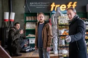 Moritz Brenner (Johannes Hendrik Langer, l.) und Jan Maybach (Marco Girnth, r.) sind gerade dabei, mit ihren Ermittlungen zu dem Mord im "Nachbarschaftstreff" zu beginnen, als pl&ouml;tzlich Simon Koschanowsky (Tino Mewes, M.) hereinplatzt. Jan bittet ihn, den Tatort zu verlassen.