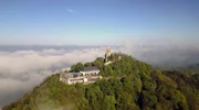Der Drachenfels im Morgennebel &uuml;ber dem Rheintal. Unterhalb der markanten Ruine liegen Aussichtsplattform und Gastronomiebetrieb, die 2013 neu gestaltet worden sind. Mit knapp 321 Metern ist der Drachenfels eine der niedrigeren Erhebungen im Siebengebirge.
