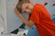 Artur h&auml;lt sich an der Boulderwand fest.