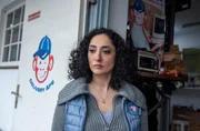 Yeliz Bulut (Ariella Hirshfeld), die Chefin von „Delivery Ape“ beobachtet mit ernstem Blick den Disput zwischen Adrian und Pablo. Yeliz Bulut (Ariella Hirshfeld), die Chefin von „Delivery Ape“ beobachtet mit ernstem Blick den Disput zwischen Adrian und Pablo.