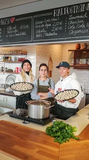Evrim zeigt Lisa und Lena in der K&uuml;che ihres Restaurants wie man t&uuml;rkische Mantis, eine Art Tortellini, zubereitet.