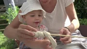 Hedda und Alma backen mit ihren beiden Mamas und ihren beiden Papas Stockbrot.