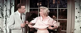 Mit dem armen Strohwitwer Richard (Tom Ewell, l.) gehen die Gef&uuml;hle durch; statt zu arbeiten, f&uuml;hlt er sich von seiner attraktiven Nachbarin (Marilyn Monroe, r.) in ihren Bann gezogen.