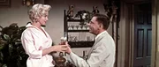 Kaum ist seine Frau aus dem Haus, "tanzen bei Richard (Tom Ewell, r.) die M&auml;use auf dem Tisch". Der Strohwitwer verliebt sich Hals &uuml;ber Kopf in seine junge Nachbarin (Marilyn Monroe, l.) ...