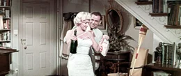 Richard (Tom Ewell, r.) ist allein zu Hause, doch statt zu arbeiten, flirtet er mit seiner sch&ouml;nen Nachbarin (Marilyn Monro, l.).