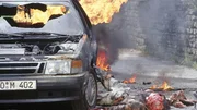 Kaminsky (Hans Peter Hallwachs) ist durch die Wucht der Explosion aus dem Auto geschleudert worden und bleibt schwer verletzt liegen.