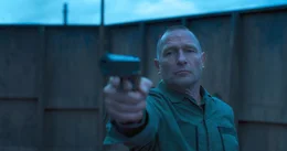 Sergeant Hendrichs (Thomas Kretschmann) mit einer Pistole.
