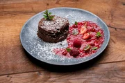 Die Nachspeise wird auf einem antrazitfarbenen Teller serviert. Es gibt einen Schoko-Käsekuchen aus eigenem Frischkäse auf Beerenspiegel. Die Nachspeise wird auf einem antrazitfarbenen Teller serviert. Es gibt einen Schoko-Käsekuchen aus eigenem Frischkäse auf Beerenspiegel.