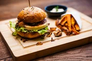 Der Gruß aus der Küche wird auf einem Holzbrett serviert. Darauf befindet sich ein Mini Käse-Burger (Frischkäse variation) dazu gibt es selbstgemachte Süßkartoffelpommes mit Mayonaise Dip. Der Gruß aus der Küche wird auf einem Holzbrett serviert. Darauf befindet sich ein Mini Käse-Burger (Frischkäse variation) dazu gibt es selbstgemachte Süßkartoffelpommes mit Mayonaise Dip.
