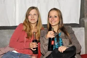 Lilly (Iris Mareike Steen, li.) und Tanja (Senta-Sofia Delliponti) am&uuml;sieren sich &uuml;ber die Tatsache, dass Zac, nachdem ihm der Geldhahn zugedreht wurde, wieder ziemlich kleine Br&ouml;tchen backen muss.