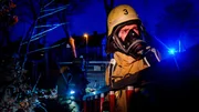 Zwei Feuerwehrm&auml;nner im Dunkeln mit Atemschutzmaske tragen eine Leiter. R&uuml;ckblick Jahreswechsel: F&uuml;r die Feuerwehr Duisburg traditionell eine der h&auml;rtesten N&auml;chte des Jahres. Die Einsatzkr&auml;fte stellen sich auf Dauerstress ein.