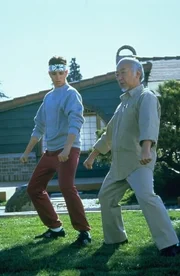 Daniel LaRusso (Ralph Macchio, l.) wird zu einem Kampf herausgefordert - doch sein Meister Mr. Miyagi (Pat Morita) will ihn nicht unterst&uuml;tzen.
