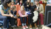 Charlie (G&eacute;raldine Raths, Mitte) kann die Bekanntgabe der Gewinnzahlen kaum erwarten. Yasemin (Sanam Afrashteh, links), Jannis (Kristo Ferkic, 2.von links), Keks und Fritz (Guido Hammesfahr, rechts) dr&uuml;cken die Daumen und Charlie ihren Gl&uuml;cksbringer.