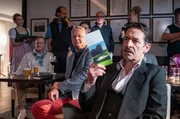 Gro&szlig;e Versammlung beim Berchtesgadener Golfplatz: Der Clubpr&auml;sident Julius Greiner (Max Tidorf, im VG. mit Komparsen im HG.) ist gegen einen Ausbau.