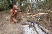 Rwanda, Akagera National Park. Ed eating a fish he has caught and cooked.