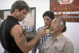 Der Karatelehrer Kreese (Martin Kove, l.) macht Miyagi (Noriyuki "Pat" Morita, r.) und Daniel (Ralph Macchio, M.) das Leben schwer. K&ouml;nnen sie sich gegen den skrupellosen Lehrer behaupten?