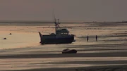 A boat stranded on the beach by the tide.