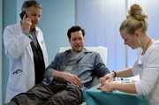 Dr. Philipp Brentano (Thomas Koch, Mitte) hat sich in die Hand gesägt. Während die Schwester (Sarah Zeising, rechts) seine Wunde erstversorgt, ruft Dr. Roland Heilmann (Thomas Rühmann) Dr. Matteo Moreau, den Handspezialisten des Johannes-Thal-Klinikums Erfurt, an und bittet ihn um Hilfe. Dr. Philipp Brentano (Thomas Koch, Mitte) hat sich in die Hand gesägt. Während die Schwester (Sarah Zeising, rechts) seine Wunde erstversorgt, ruft Dr. Roland Heilmann (Thomas Rühmann) Dr. Matteo Moreau, den Handspezialisten des Johannes-Thal-Klinikums Erfurt, an und bittet ihn um Hilfe.