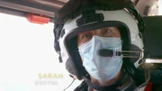 Doctor Sarah talking to camera in the back of the helicopter