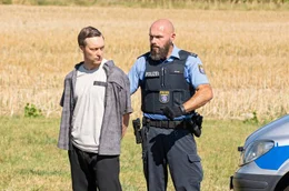 Erste Tatortbegehung &ndash; Stephan Ernst (Robin Sondermann, links) wird von einem Polizeibeamten an den Tatort gef&uuml;hrt.