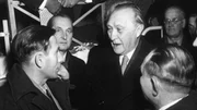 Als Konrad Adenauers gr&ouml;&szlig;ten Verdienst gilt die Heimholung der letzten 10.000 Kriegsgefangenen aus russischen Lagern - zehn Jahre nach Kriegsende. - Konrad Adenauer (2.v.r.) im Durchgangslager Friedland, Niedersachsen, 1954. Adenauer im Gespr&auml;ch mit Heimkehrern nach ihrer Freilassung aus sowjetischer Kriegsgefangenschaft.