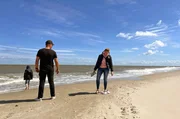 Sofia (r) und Carsten Rudolf mit ihrem Sohn Paul (l) am Strand von Texel.