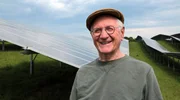 Hans Well im Porträt mit PV Anlage im Hintergrund. Hans Well im Porträt mit PV Anlage im Hintergrund.