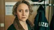Blum (Anna Maria Mühe) sieht zu, wie sich ihr vermeintlicher Anwalt mit Majorin Wallner unterhält. Blum (Anna Maria Mühe) sieht zu, wie sich ihr vermeintlicher Anwalt mit Majorin Wallner unterhält.