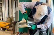 Vorarbeiten des Handwerkers: Spengler Manfred Hofmann falzt die Kanten des Wasserfangkastens aus Zinkblech in seiner Werkstatt in Singhofen Rheinland-Pfalz.