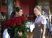 Lea (Sandra Speichert, li.) hat von ihrem Verflossenen einen Strau&szlig; Rosen geschickt bekommen und bittet Zimmerm&auml;dchen Lucy (Marisa Leonie Bach), sie als Tischdekoration zu verwenden.
