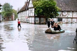 Der Film blickt auf die dramatischen Ereignisse im Juli 1965 zur&uuml;ck, als Ostwestfalen-Lippe von der schwersten Hochwasserkatastrophen der Nachkriegszeit heimgesucht wurde. Auch Teile von Niedersachsen, Hessen und der damaligen DDR wurden &uuml;berflutet. Besonders hart traf das Hochwasser das Dorf Etteln s&uuml;dlich von Paderborn. Wegen seiner Tallage lief das Dorf voll wie eine Wanne, Menschen k&auml;mpften ums &Uuml;berleben, w&auml;hrend die Helfer fieberhaft und oft vergeblich versuchten, die Eingeschlossenen zu retten. - Der Gasthof Voss in Lipperode nach dem Dammbruch (Foto nachcoloriert mit KI)
