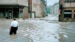 Der Film blickt auf die dramatischen Ereignisse im Juli 1965 zur&uuml;ck, als Ostwestfalen-Lippe von der schwersten Hochwasserkatastrophen der Nachkriegszeit heimgesucht wurde. Auch Teile von Niedersachsen, Hessen und der damaligen DDR wurden &uuml;berflutet. Besonders hart traf das Hochwasser das Dorf Etteln s&uuml;dlich von Paderborn. Wegen seiner Tallage lief das Dorf voll wie eine Wanne, Menschen k&auml;mpften ums &Uuml;berleben, w&auml;hrend die Helfer fieberhaft und oft vergeblich versuchten, die Eingeschlossenen zu retten. - Paderborn,  Giersmauer Ecke Giersstra&szlig;e. Ein Anwohner checkt die Lage (Foto nachcoloriert mit KI)