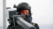 Eine Soldatin zielt mit einem "Drone-Buster" auf eine anfliegende Drohne.