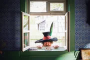 Der R&auml;uber Hotzenplotz (Nicholas Ofczarek) liegt am K&uuml;chenfenster der Gro&szlig;mutter auf Lauer. Er hat es auf ihre hei&szlig; geliebte Kaffeem&uuml;hle abgesehen.