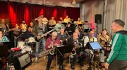 Doc Esser (stehend mit Gitarre) performt mit der Big Band Bergisch Gladbach. Einen Teil der Truppe coacht er in ein ges&uuml;nderes und fitteres Leben.