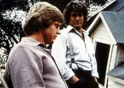 Charles Ingalls (Michael Landon, r.) betrachtet sich mit seinem Schwiegersohn Almanzo Wilder (Dean Butler, l.) dessen Haus, das bei einem Tornado zerst&ouml;rt wurde.