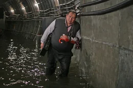 Wasser aus der Moskwa dringt &uuml;ber undicht gewordenes Deckenwerk in die Kan&auml;le ein, weil der einzige Mann, der die Menschen h&auml;tte warnen k&ouml;nnen, in der Ausn&uuml;chterungszelle hockt.
