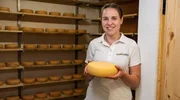 Magdalena Kaiser steht in ihrem Reiferaum und hält einen Laib selbstgemachten Käse in der Hand. Magdalena Kaiser steht in ihrem Reiferaum und hält einen Laib selbstgemachten Käse in der Hand.